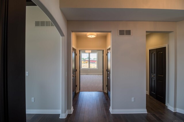 63725 Mulberry Dr, Washington Twp, MI 48095 - corridor featuring visible vents, arched walkways, baseboards, and dark wood-style floors