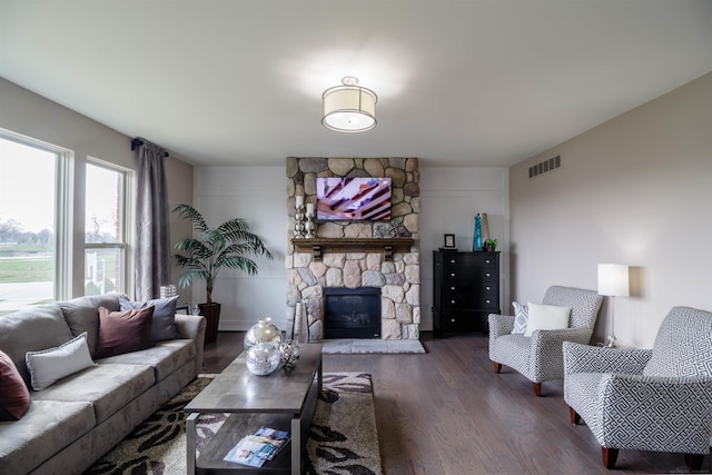 living room with dark wood-type flooring and a fireplace