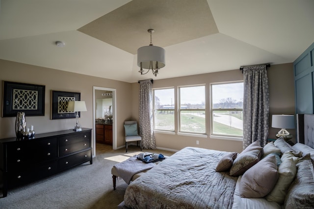 bedroom with lofted ceiling, carpet flooring, and ensuite bath