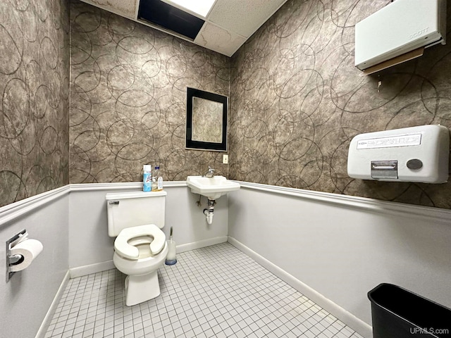 bathroom featuring toilet, sink, and tile patterned flooring