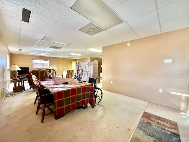 carpeted dining area with a drop ceiling