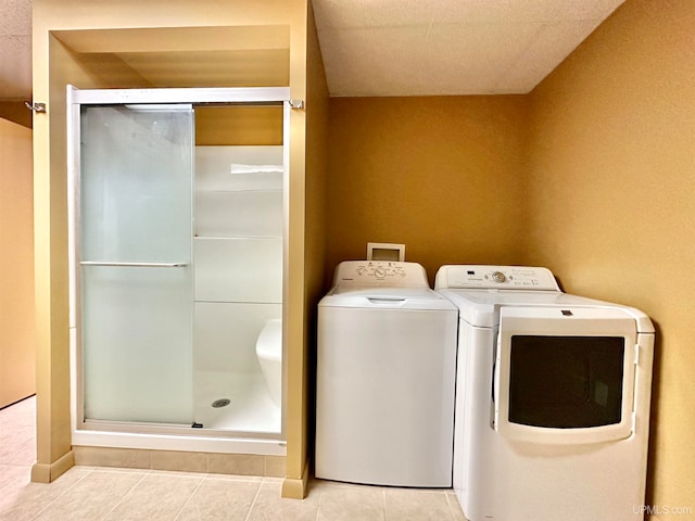 laundry room with washing machine and dryer and light tile patterned floors