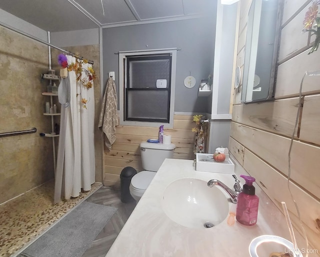 bathroom with toilet, wood walls, vanity, and curtained shower