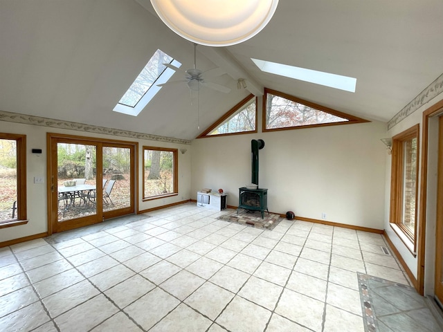 unfurnished living room with vaulted ceiling with beams, ceiling fan, light tile patterned flooring, and a wood stove