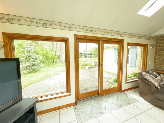 doorway to outside featuring light tile patterned floors and lofted ceiling with skylight