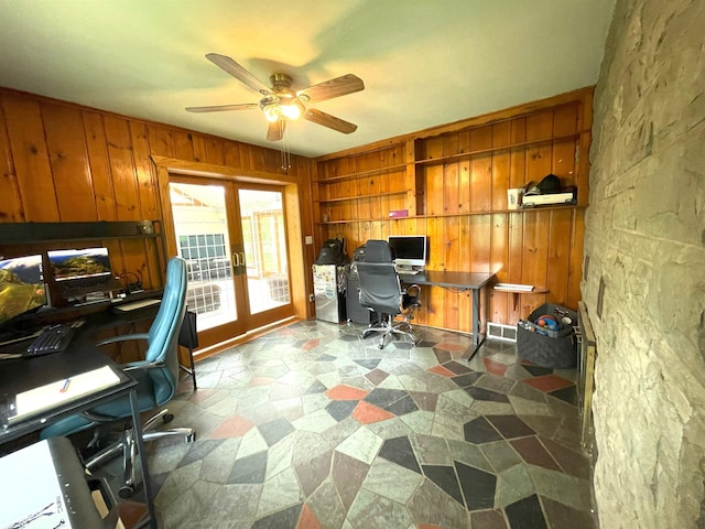 office featuring built in shelves, wood walls, french doors, and ceiling fan