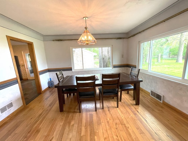 dining room featuring an inviting chandelier and light wood-type flooring