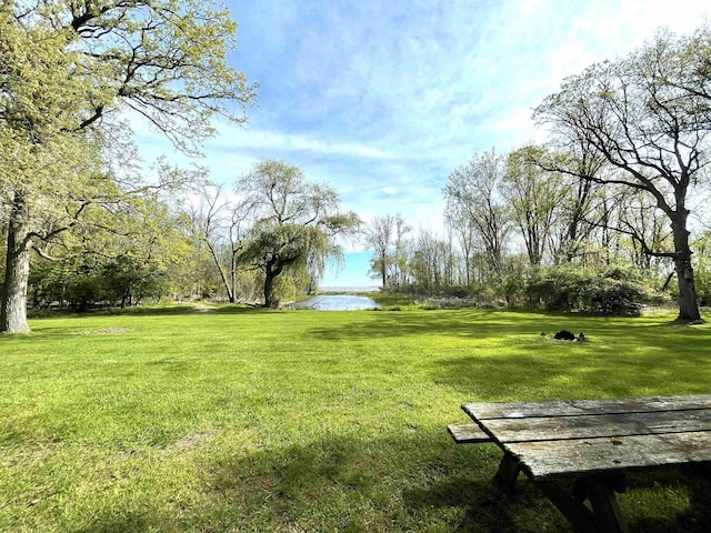 surrounding community with a lawn and a water view