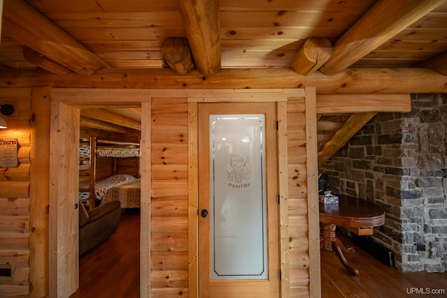 entryway with wood ceiling, rustic walls, beam ceiling, and dark hardwood / wood-style floors