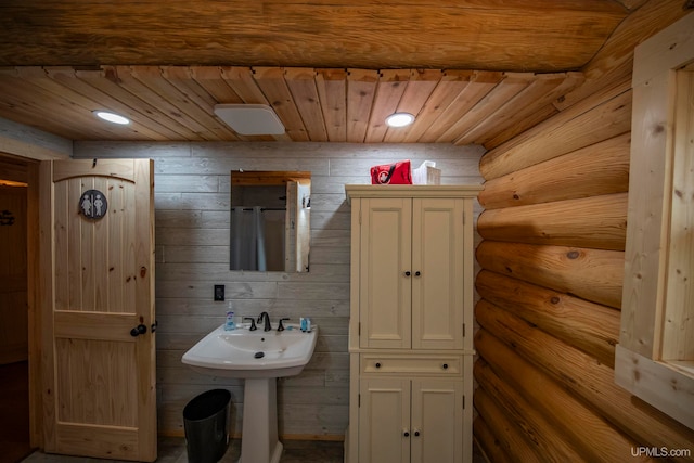 bathroom with rustic walls and wooden ceiling