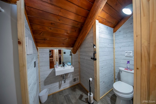 bathroom with hardwood / wood-style floors, wooden ceiling, vaulted ceiling, toilet, and wooden walls