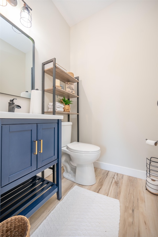 bathroom featuring vanity, wood-type flooring, and toilet