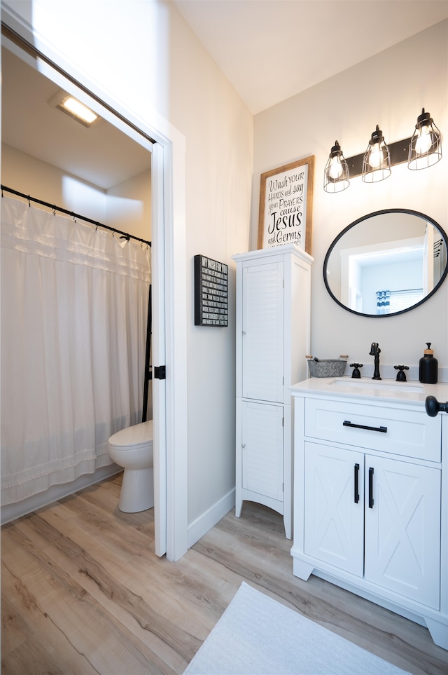 bathroom featuring vanity, toilet, wood-type flooring, and a shower with curtain