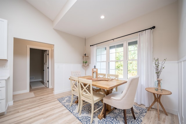 dining room with light hardwood / wood-style flooring and lofted ceiling