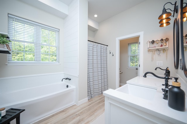 bathroom featuring vanity, hardwood / wood-style floors, shower with separate bathtub, and plenty of natural light