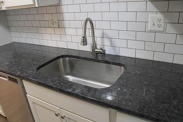 room details with dark stone countertops, tasteful backsplash, sink, and dishwasher