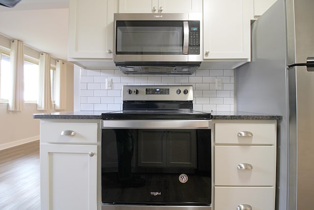 kitchen featuring white cabinetry, hardwood / wood-style flooring, stainless steel appliances, and decorative backsplash