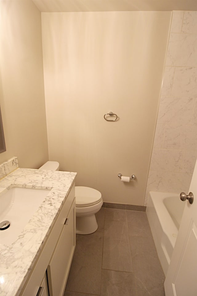 bathroom featuring vanity, a bathtub, toilet, and tile patterned flooring