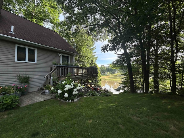 view of yard with a deck with water view