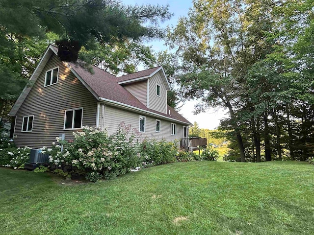 view of side of property featuring a wooden deck and a lawn