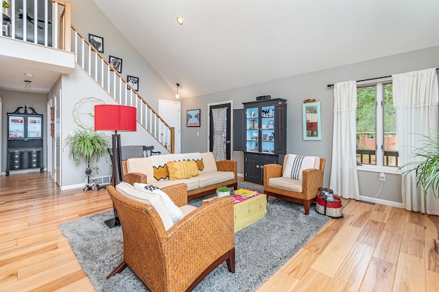 living room with high vaulted ceiling and wood-type flooring