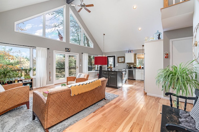 living room featuring light hardwood / wood-style floors, high vaulted ceiling, and ceiling fan