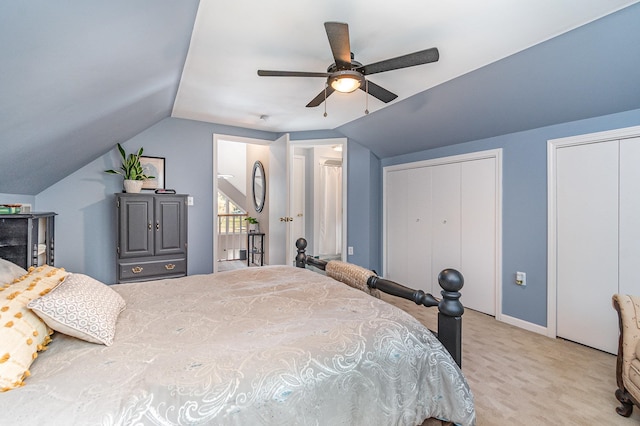 bedroom with lofted ceiling, two closets, light colored carpet, and ceiling fan