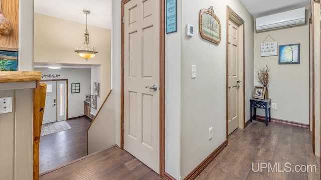 corridor with a wall unit AC and dark hardwood / wood-style floors