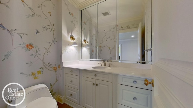 bathroom featuring toilet, ornamental molding, and vanity