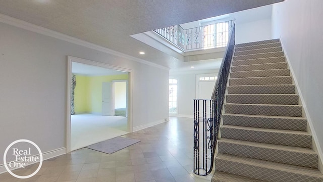 stairs featuring crown molding and a textured ceiling