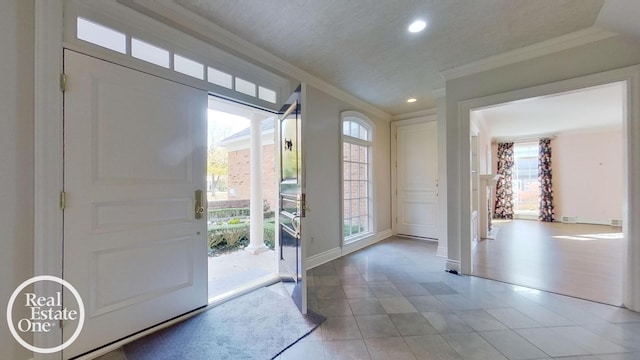 entryway featuring crown molding and light tile patterned flooring