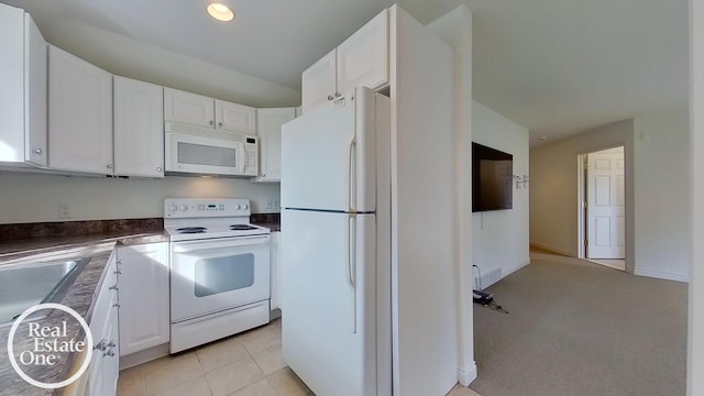 kitchen with white appliances, light tile patterned floors, sink, and white cabinets