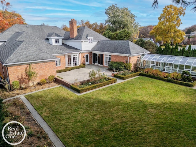 rear view of property with a patio area, a lawn, and a lanai