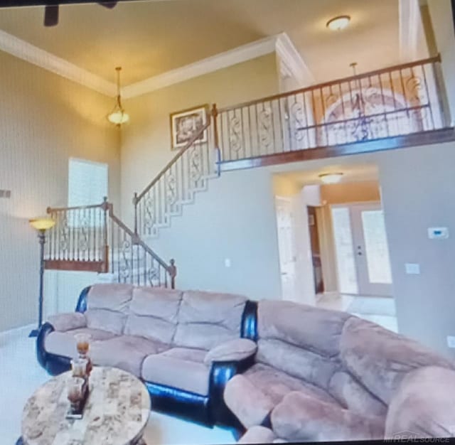 living room with crown molding, french doors, and a high ceiling