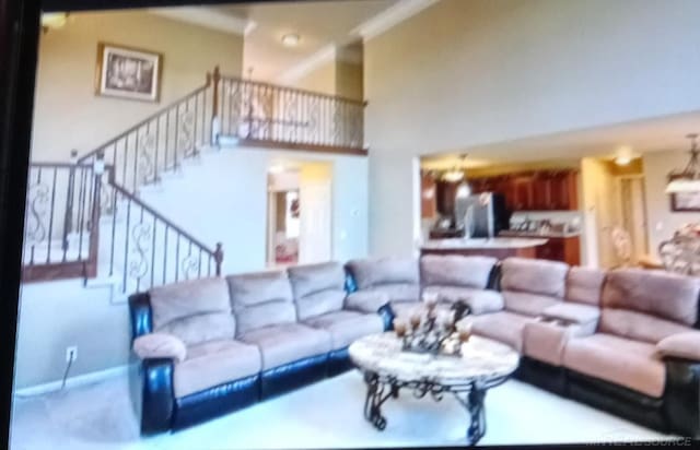 carpeted living room featuring a high ceiling