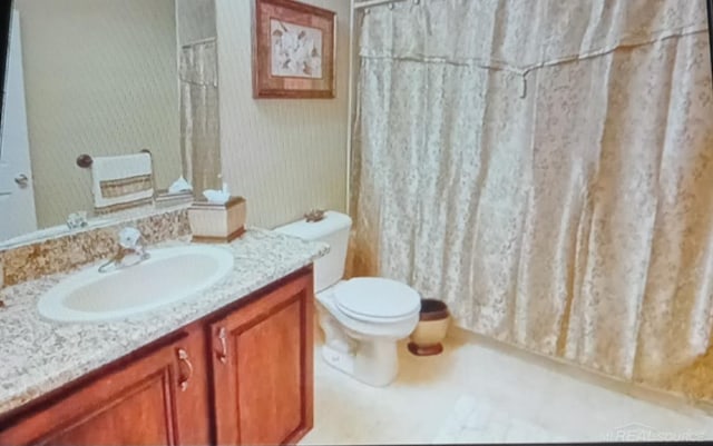 bathroom featuring toilet, vanity, and a shower with shower curtain