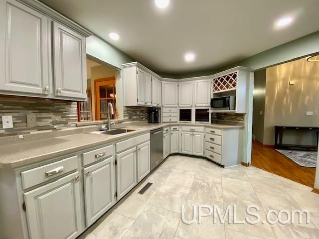 kitchen with decorative backsplash, sink, stainless steel appliances, and light hardwood / wood-style flooring