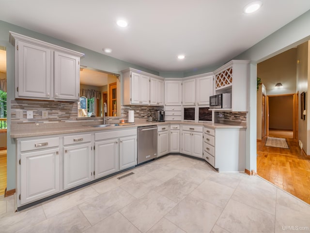 kitchen with decorative backsplash, stainless steel appliances, white cabinetry, and sink