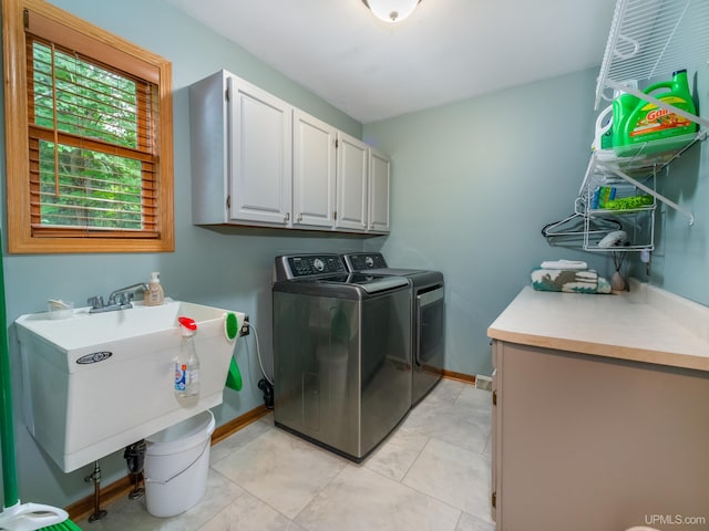 laundry room with washer and clothes dryer, cabinets, and sink