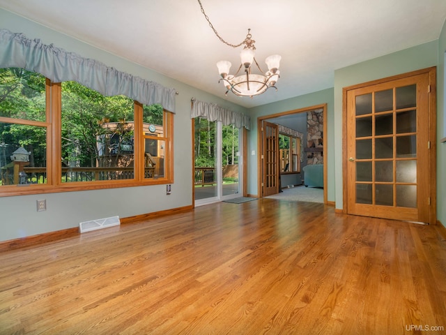 spare room featuring light hardwood / wood-style floors and an inviting chandelier