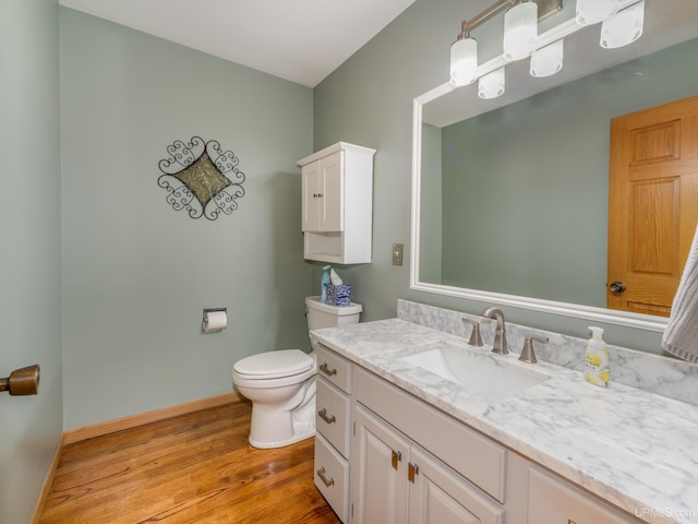 bathroom featuring toilet, vanity, and hardwood / wood-style flooring