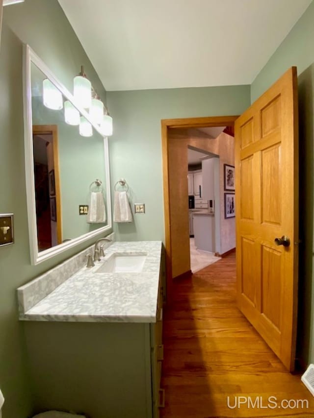 bathroom with hardwood / wood-style floors and vanity