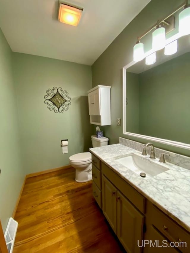 bathroom with hardwood / wood-style flooring, vanity, and toilet