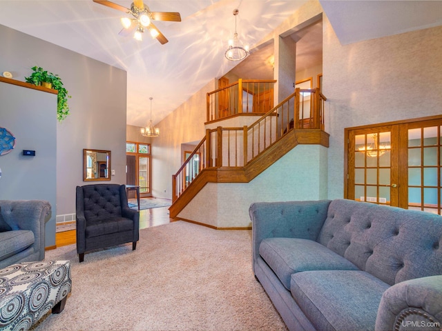 living room featuring carpet flooring, french doors, high vaulted ceiling, and ceiling fan with notable chandelier