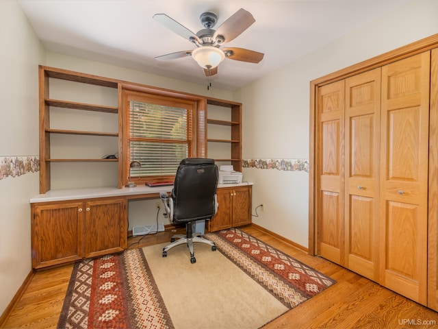 home office with ceiling fan, light hardwood / wood-style flooring, and built in desk