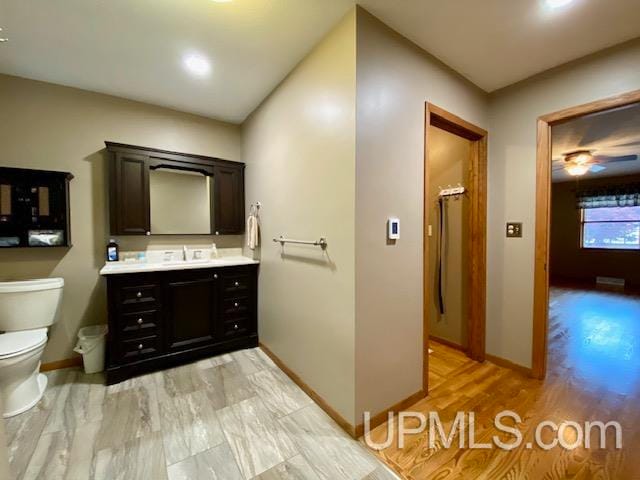 bathroom with hardwood / wood-style flooring, vanity, and toilet