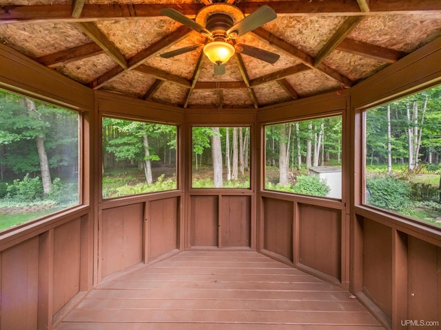 unfurnished sunroom with ceiling fan and vaulted ceiling