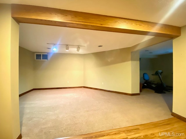 basement with hardwood / wood-style floors and rail lighting