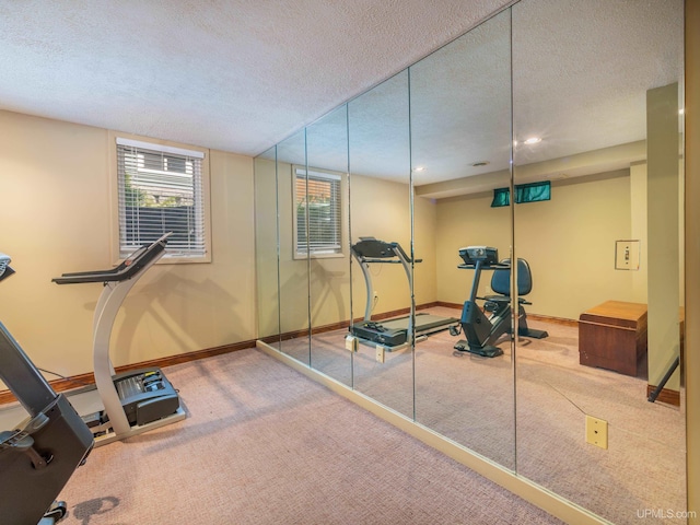 exercise room with carpet flooring and a textured ceiling