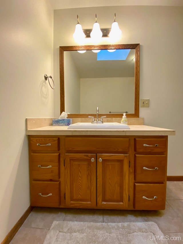 bathroom featuring vanity, a skylight, and tile patterned floors